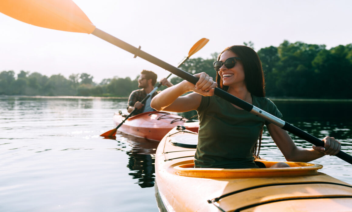 Nice day for kayaking. Beautiful young couple kayaking on lake t