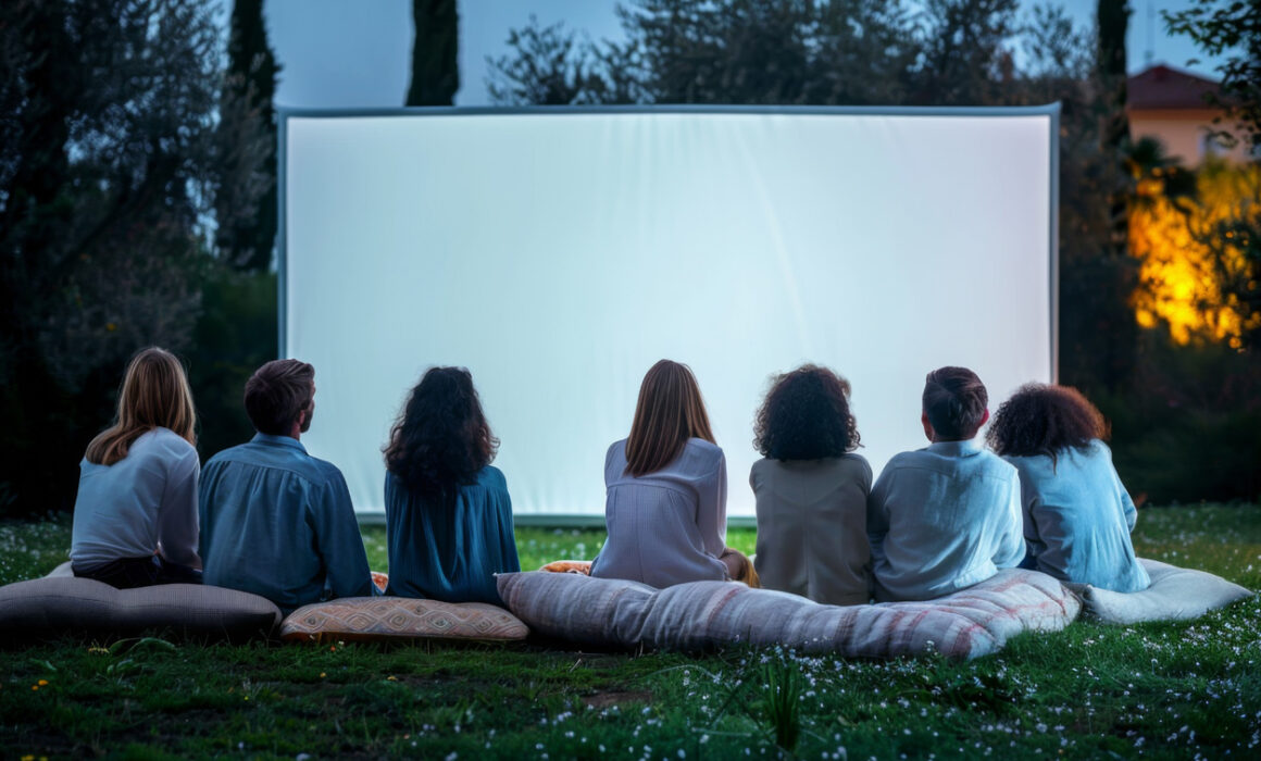 group of people sitting outdoors watching movie