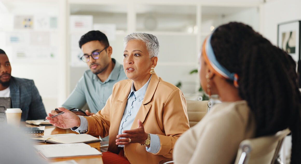 Senior, woman or business people in meeting with talking in teamwork for creative decision making. Collaboration, manager or professional employees with paperwork for project brainstorming in office
