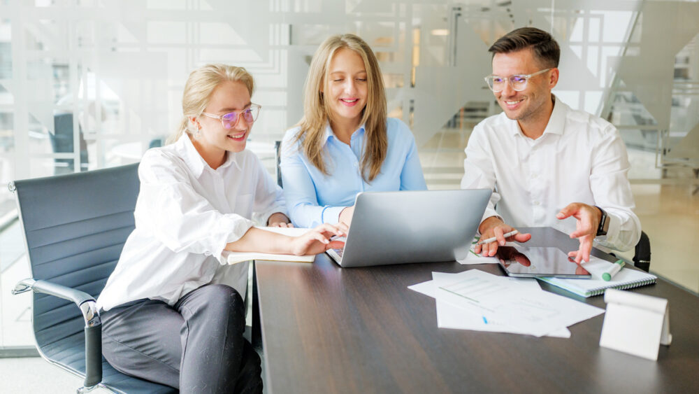 Downloaded Team members working together on project in office
